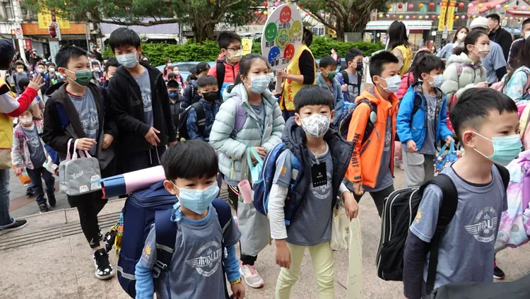 小朋友乖乖戴口罩進學校。莊宗達攝