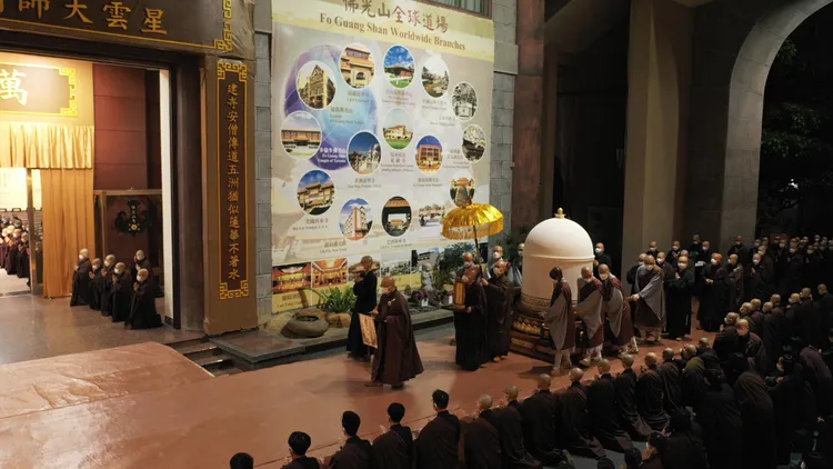 僧信二眾在天色拂曉的清晨列隊跪接，整齊莊嚴的隊伍一路從傳燈樓綿延至佛光山雲居樓。圖/人間社記者莊佳穎