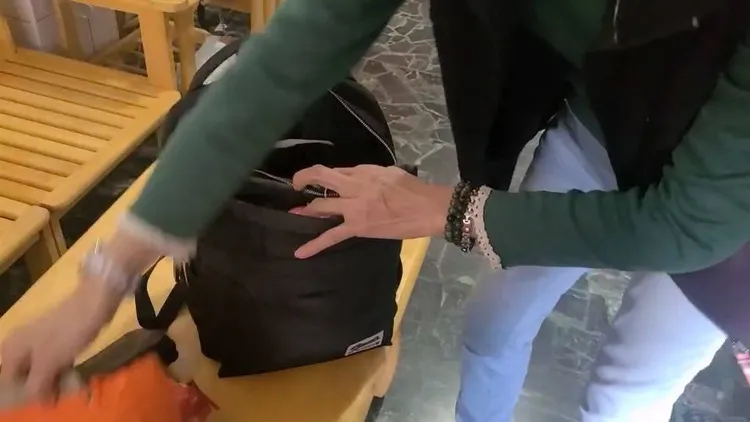 蔡姓婦人打開背包，確認裡面的87萬元未短少。讀者提供