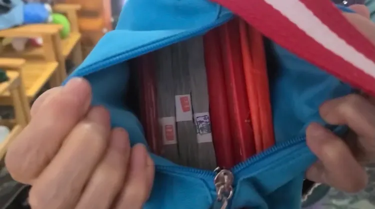 蔡姓婦人打開背包，確認裡面的87萬元未短少。讀者提供