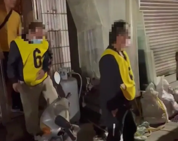 賭客穿上鮮明的黃色數字背心，從民宅賭場內出來上警車。翻攝畫面