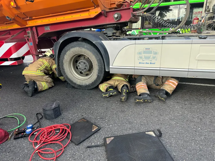 警消鑽入車底救人。讀者提供