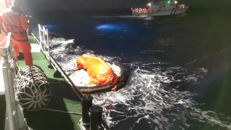 水瓶座號後方拖曳載有白色麻布袋的救生筏。調查局提供