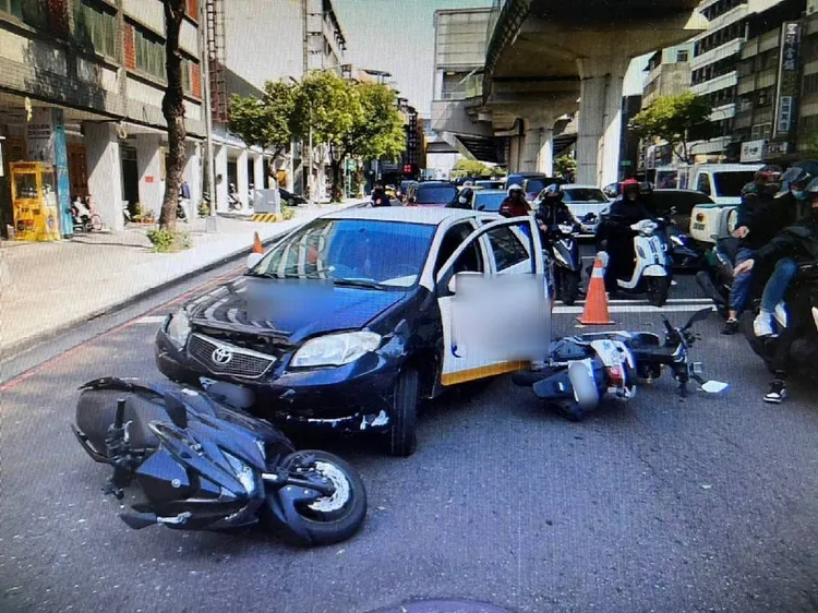 肇事自小客在路口突然大迴轉，穿越安全島回到原車道，撞上二部停等紅燈機車。讀者提供