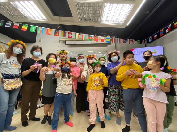 參與的新住民朋友及二代開心地戴著完成的花圈合影。移民署提供