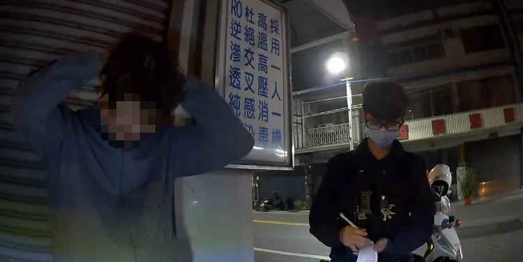 李男（右）七度酒駕被警方攔檢，體認難逃牢獄之災，沮喪地抓頭。讀者提供