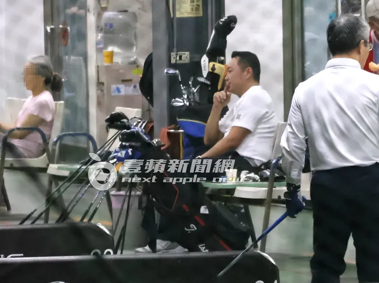 張克帆（中）打了4個鐘頭，終於坐下來休息，加減指導球友揮桿姿勢。特勤中心攝