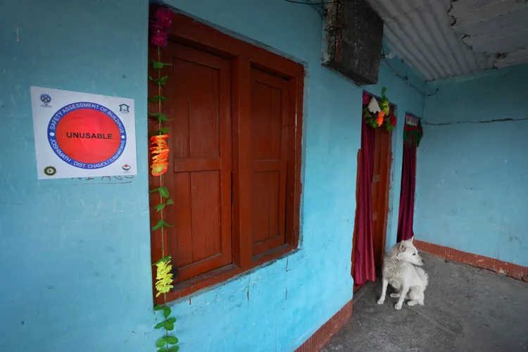 這戶民宅已無人居住，只有狗狗還在門口徘徊，窗旁也被貼了「無法使用」。美聯社