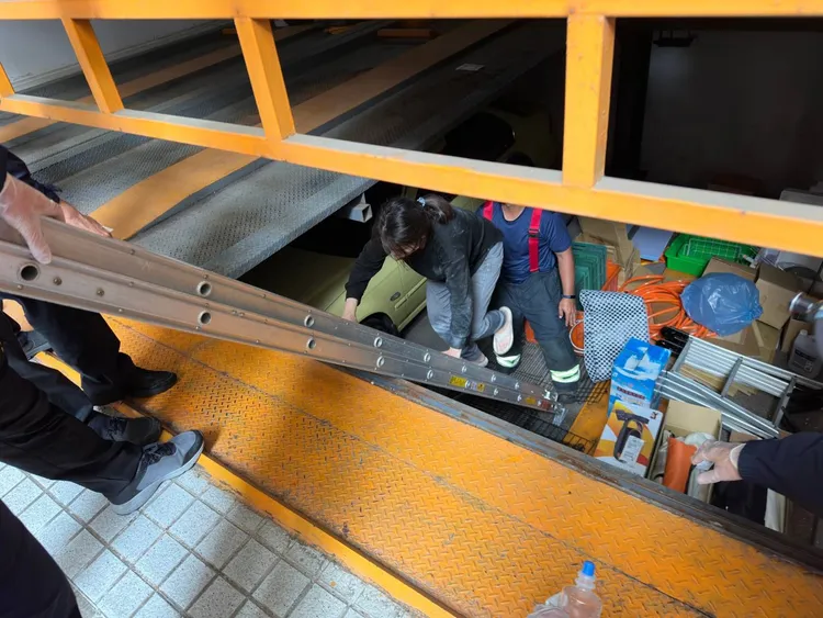 警消協助摔落到機械停車格下方的趙女脫困。讀者提供