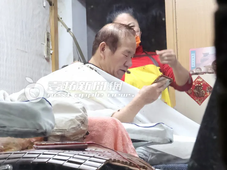 趙傳脫下帽子，跟地方媽媽邊看手機影片笑開懷。特勤中心攝