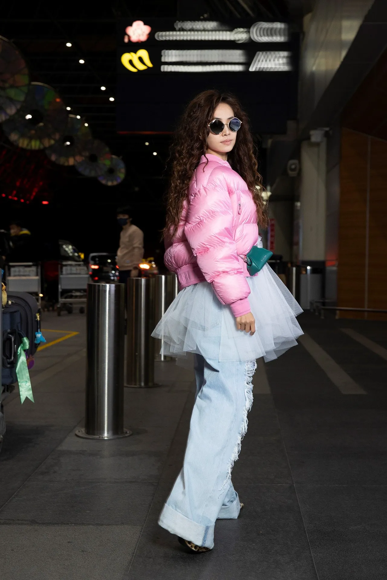 蔡依林搭機裝扮以白色運動短上衣、破損牛仔寬褲、粉紅短版羽絨外套再疊加白色網紗蛋糕裙的多層次搭配,還有豹紋尖頭高跟鞋,展現個性十足又顯氣勢風貌。品牌提供