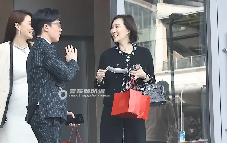 錢德月（右）手拿著口罩及手機還有紙袋，看似心情不錯。特勤中心攝