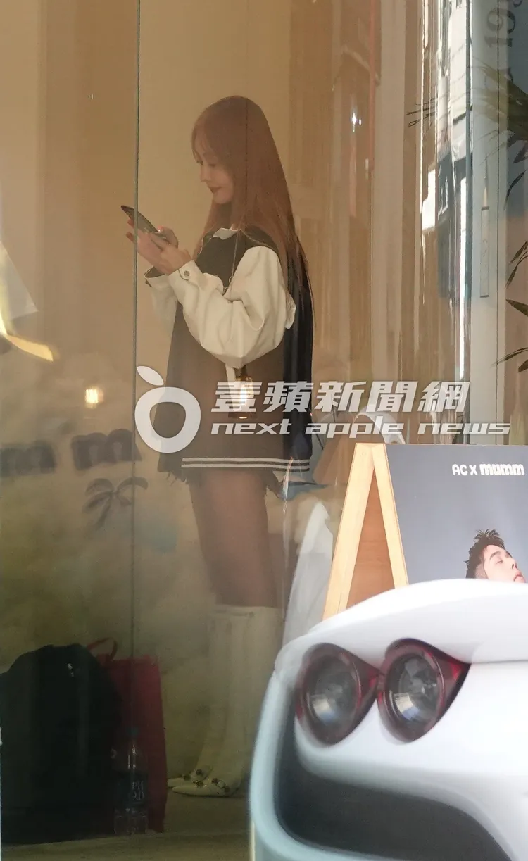 資工彌在店內穿起外套滑著手機。特勤中心攝