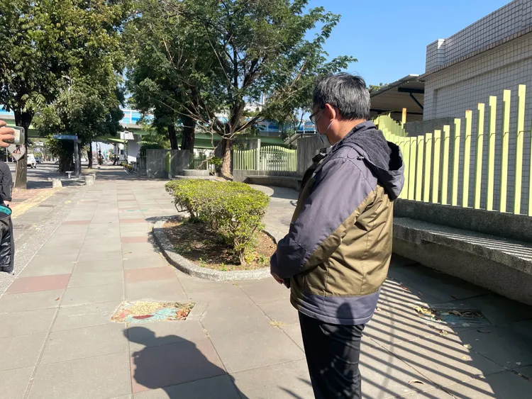 楠梓國中學務主任黃建源無奈地望向環保局垃圾車司機每天亂便溺的人行道花圃。讀者提供