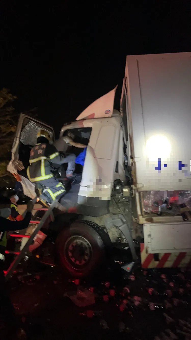 消防人員搶救受困駕駛座的聯結車駕駛。民眾提供