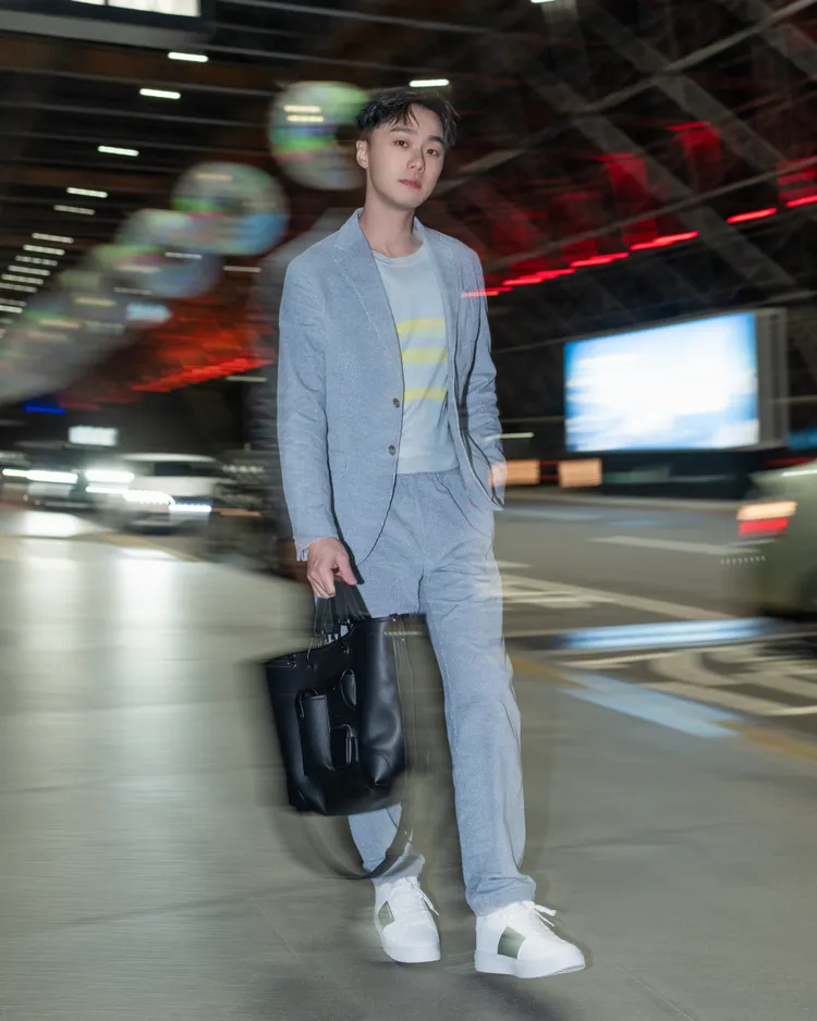 施柏宇以全套EMPORIO ARMANI水藍色休閒西裝搭配螢光條紋針織衫，穿出兼容正式與休閒的義式瀟灑氣魄。品牌提供