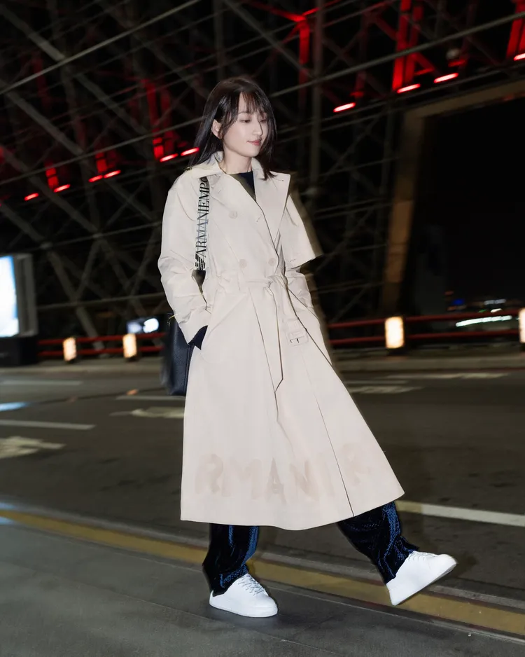 柯佳嬿以EMPORIO ARMANI卡其色風衣搭配深藍色長褲、白色休閒鞋的造型現身機場，輕鬆中不失氣質。品牌提供