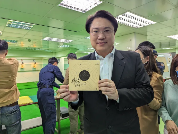 林右昌親自體驗空氣槍打靶，更在靶紙上簽名。蘇柏銓攝
