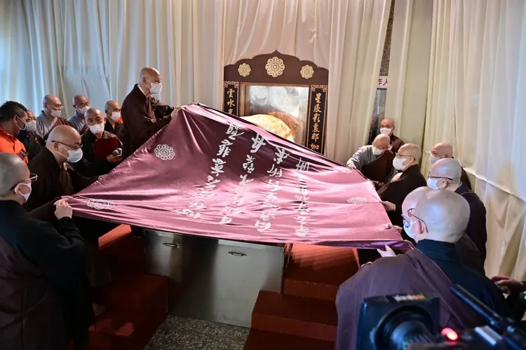 長老們為大師棺槨覆蓋經被，被上繡著大師自撰詩偈：「心懷度眾慈悲願，身似法海不繫舟；問我一生何所求，平安幸福照五洲。」圖／人間社提供