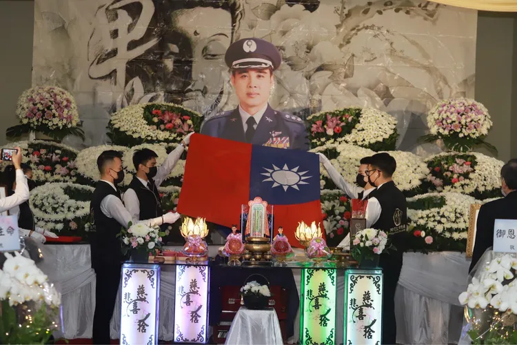 兵家綺為父親棺木蓋上國旗。民視提供