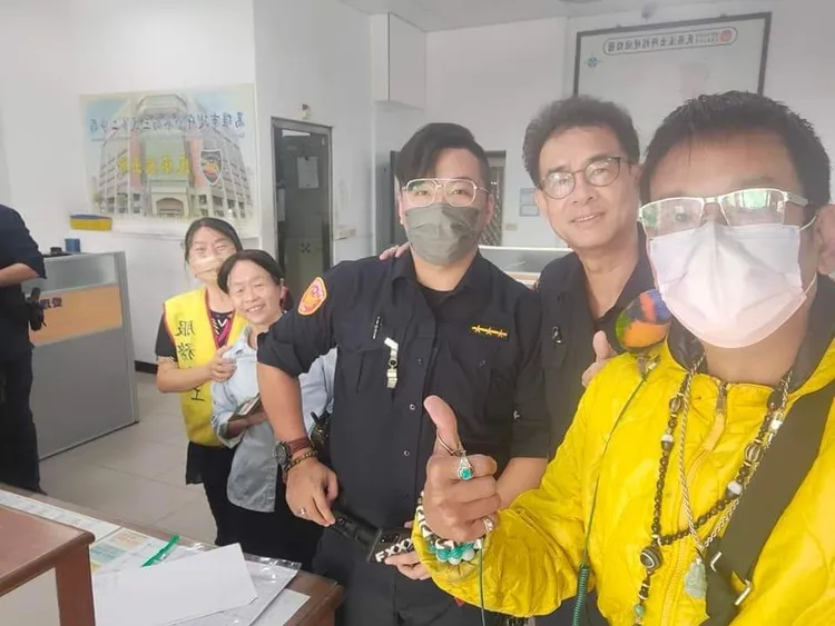 江姓失主到派出所領回「古錐」，牠乖乖站在主人肩膀上。讀者提供