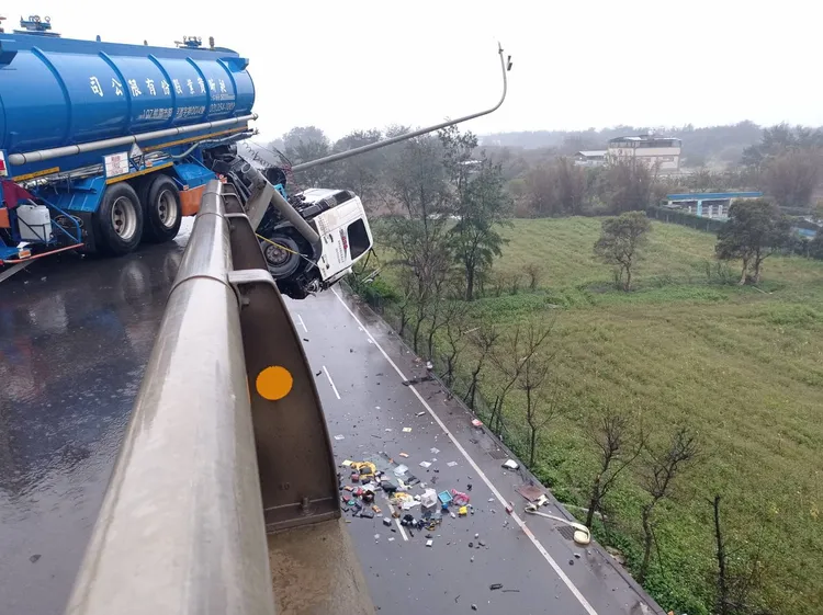化學槽車衝破台61線護欄後，槽車車頭懸空朝下，駕駛與車內物品皆掉落至地面。翻攝畫面