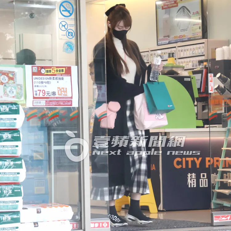 短今穿休閒鞋，斜背粉紅色包包逛便利商店。特勤中心攝。