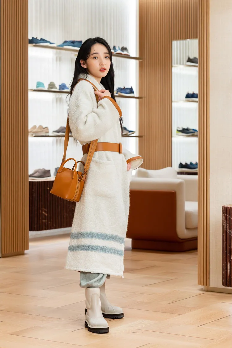 李沐演繹Loro Piana 2023春夏女裝系列，以小山羊喀什米爾的針織衫和縮口長褲，搭配絨毛皮革緄邊綁帶長版大衣和拼接高筒靴，做出率性又顯氣場的造型。大衣22萬4400元、針織衫5萬6300元、長褲7萬6300元、Bale Bag中型款8萬1500元。品牌提供