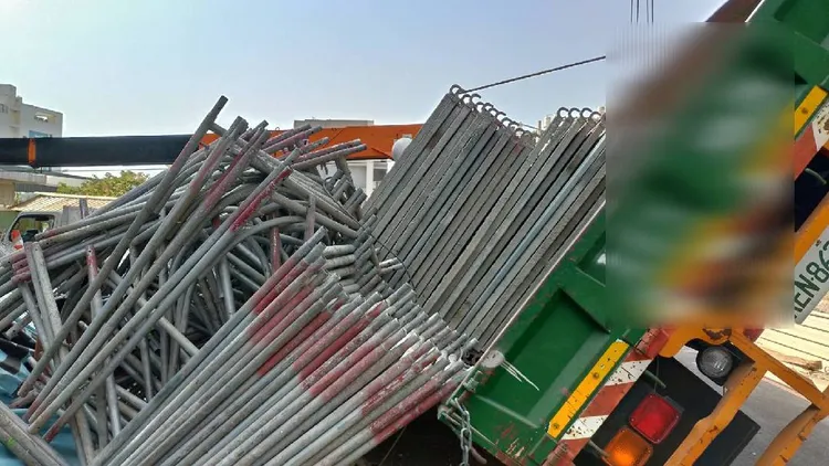 一輛載有鷹架的拖板車，卸貨時側翻，壓住兩名工人，一人當場失去呼吸心跳，另一名頭部外傷。讀者提供