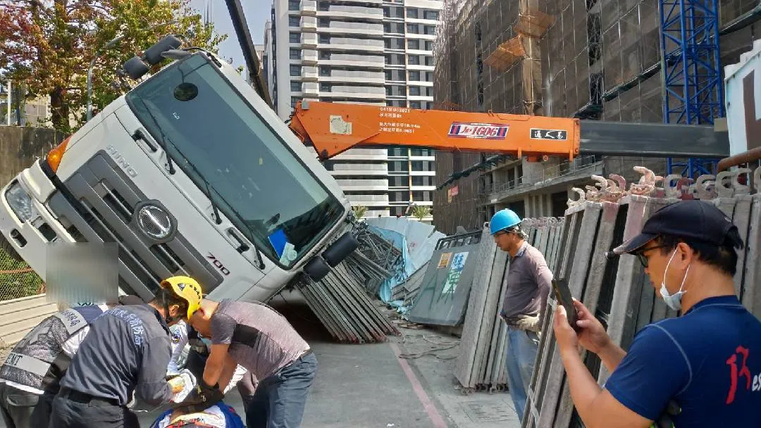 一輛載有鷹架的拖板車,卸貨時側翻,壓住兩名工人,一人當場失去呼吸心跳,另一名頭部外傷。讀者提供
