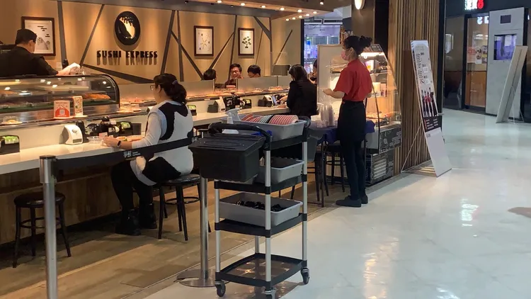 高雄一名婦人指她到爭鮮愛河店用餐，卻看到鄰座男子將摸過食物，再放回壽司軌道上。讀者提供