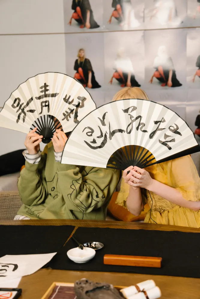 2人各自拿著對方送給自己的書法成品。環球音樂提供