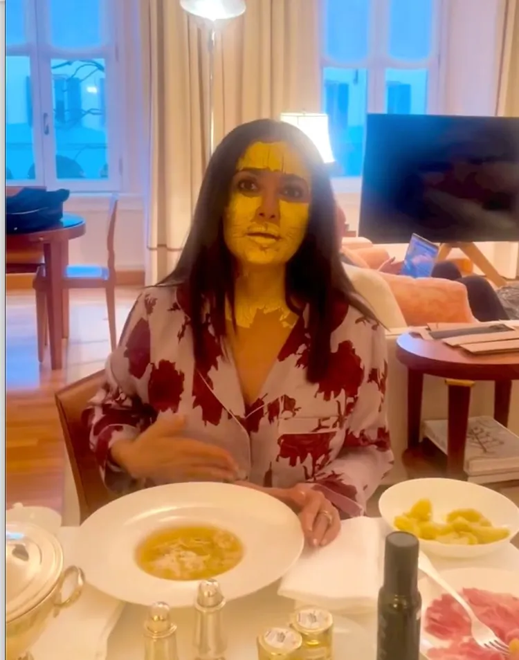 莎瑪海耶克穿著睡衣、臉上到頸間敷著金色泥狀面膜，面對著滿桌食物忍不住要食指大動。翻攝salmahayek IG