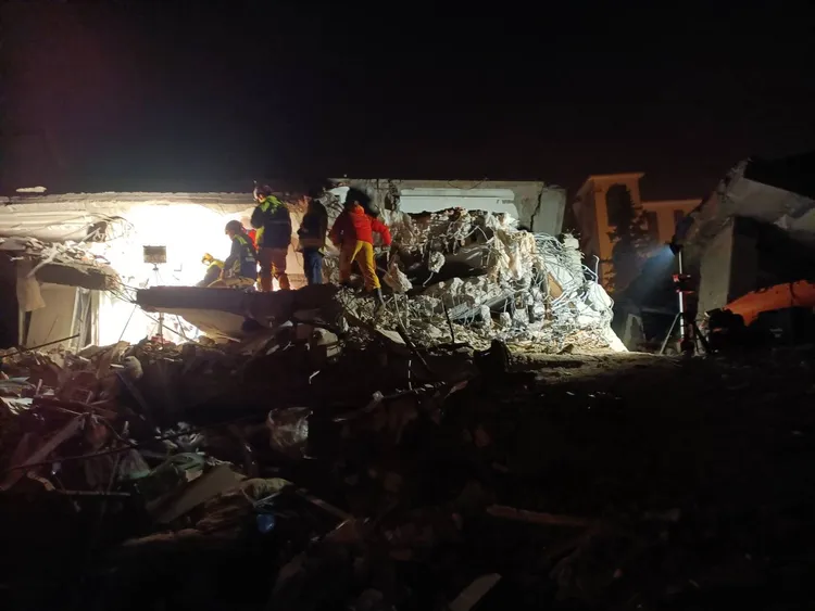 台灣搜救隊員於斷垣殘瓦中，努力尋找受困者。翻攝畫面