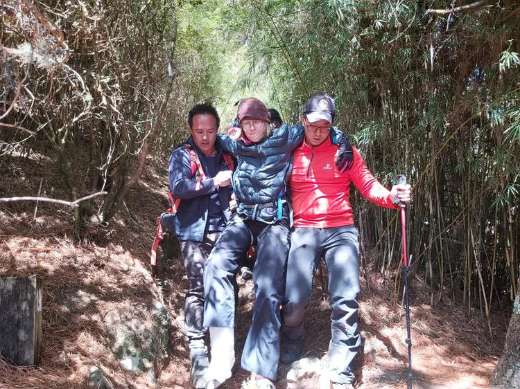 搜救人員以輪流揹負、攙扶方式，花了近3小時將受傷的美籍女登山客帶下山。民眾提供