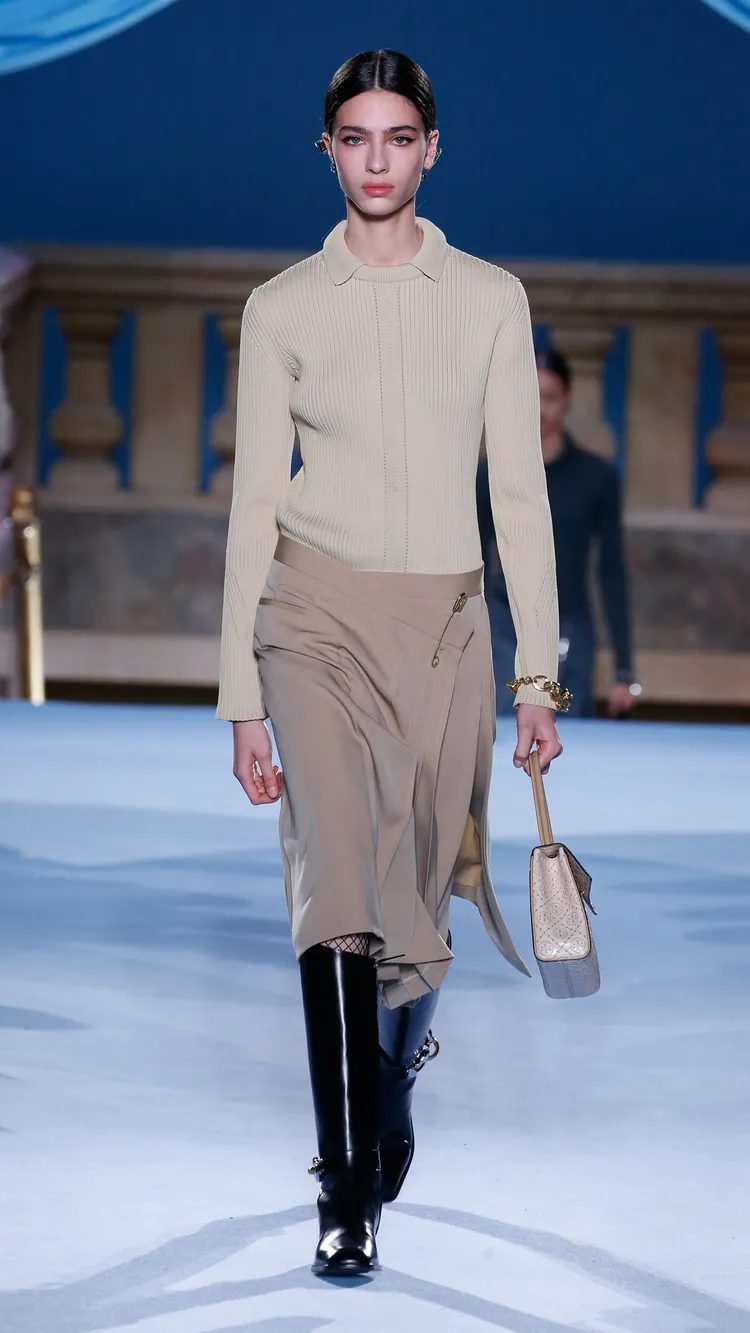 開場造型中以巨型安全別針固定住不對稱腰頭的褶飾裙，充分表達出了本季TORY BURCH強調「不完美之美」的主題。品牌提供