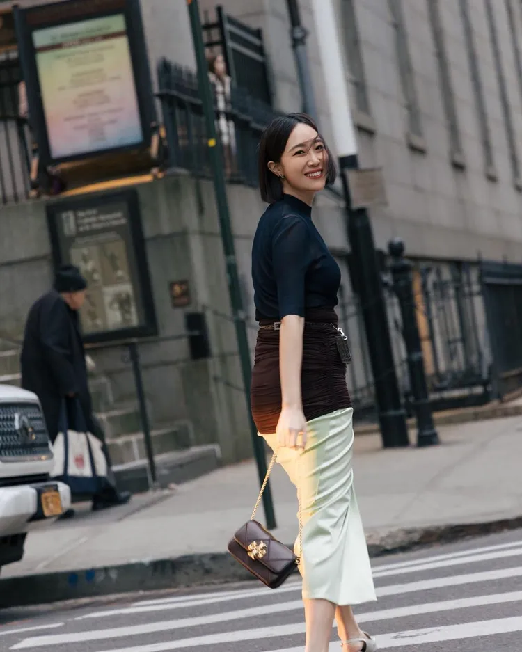 以TORY BURCH透視上衣搭配及膝裙造型入鏡的Melinda，整體看來身材依舊玲瓏有致，唯獨一些自側面拍攝的角度，才可見她微微隆起的孕肚。品牌提供