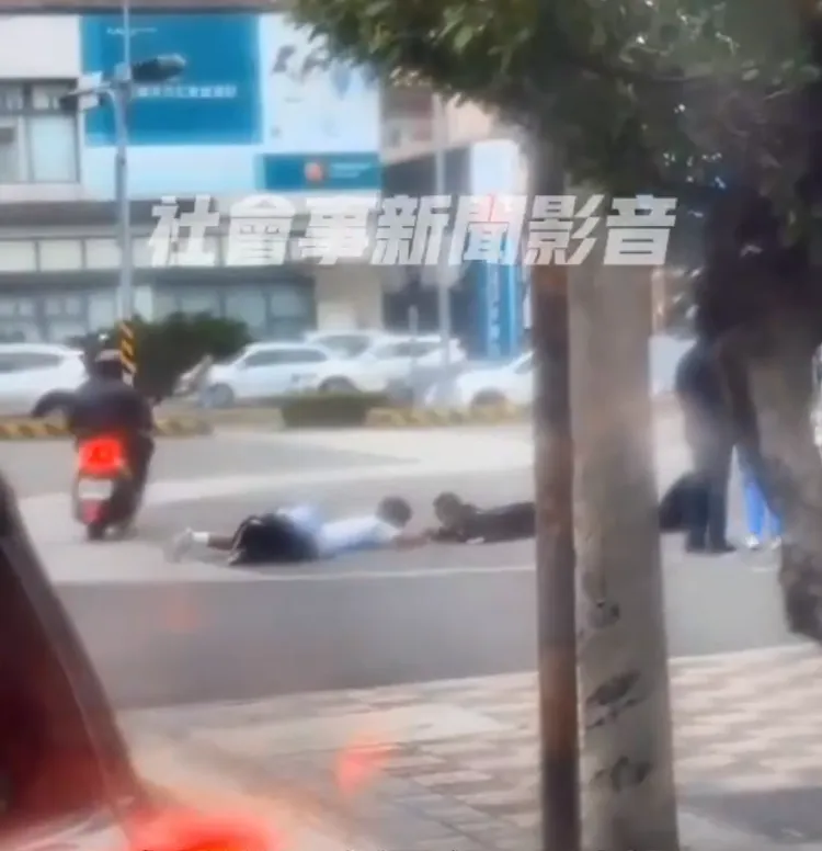 二名學生完全無視行經人車異樣目光，依然故我趴地玩起遊戲。翻攝社會事新聞影音