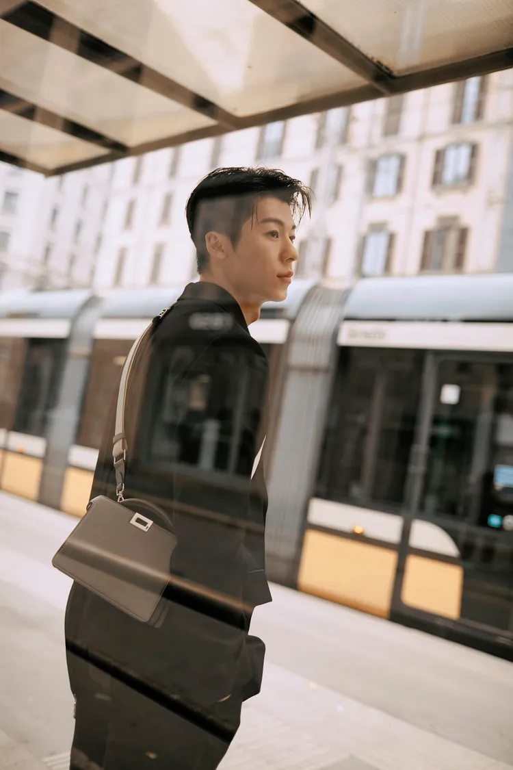 許光漢穿著黑色系的FENDI春夏系列西裝外套與黑色長褲，搭配男性Peekaboo Xcross包款。品牌提供