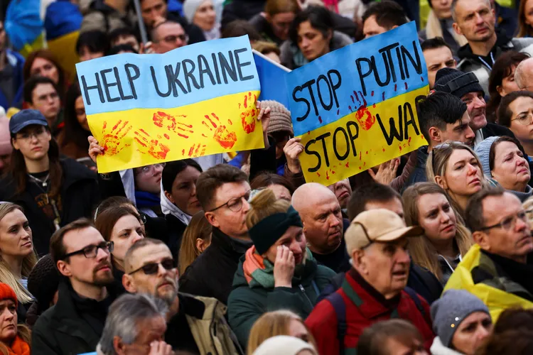 示威民眾手持「幫助烏克蘭」、「阻止普丁阻止戰爭」標語，路透社