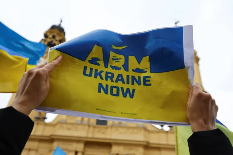 民眾手持「現在武裝烏克蘭」標語。路透社