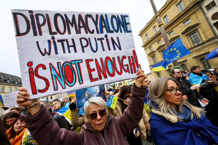 民眾手持「對普丁（用）外交手段不夠」標語。路透社