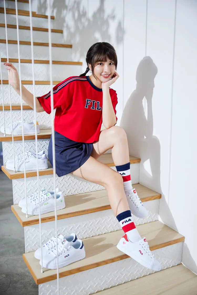 峮峮代言FILA的形象照，展現甜美氣息。學院風短版紅色運動上衣1980元、吸排抗UV短裙1980元、情人節限定塗鴉小白鞋2080元。品牌提供