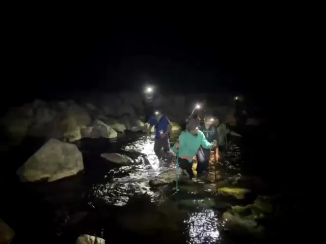 消防人員護送陳女沿著溪谷下山，花了7個小時完成救援任務。民眾提供