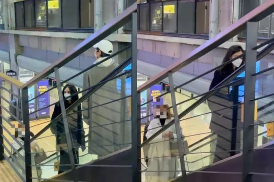 宋仲基戴白色棒球帽，搭手扶梯刻意與凱蒂保持距離。翻攝Moneytoday