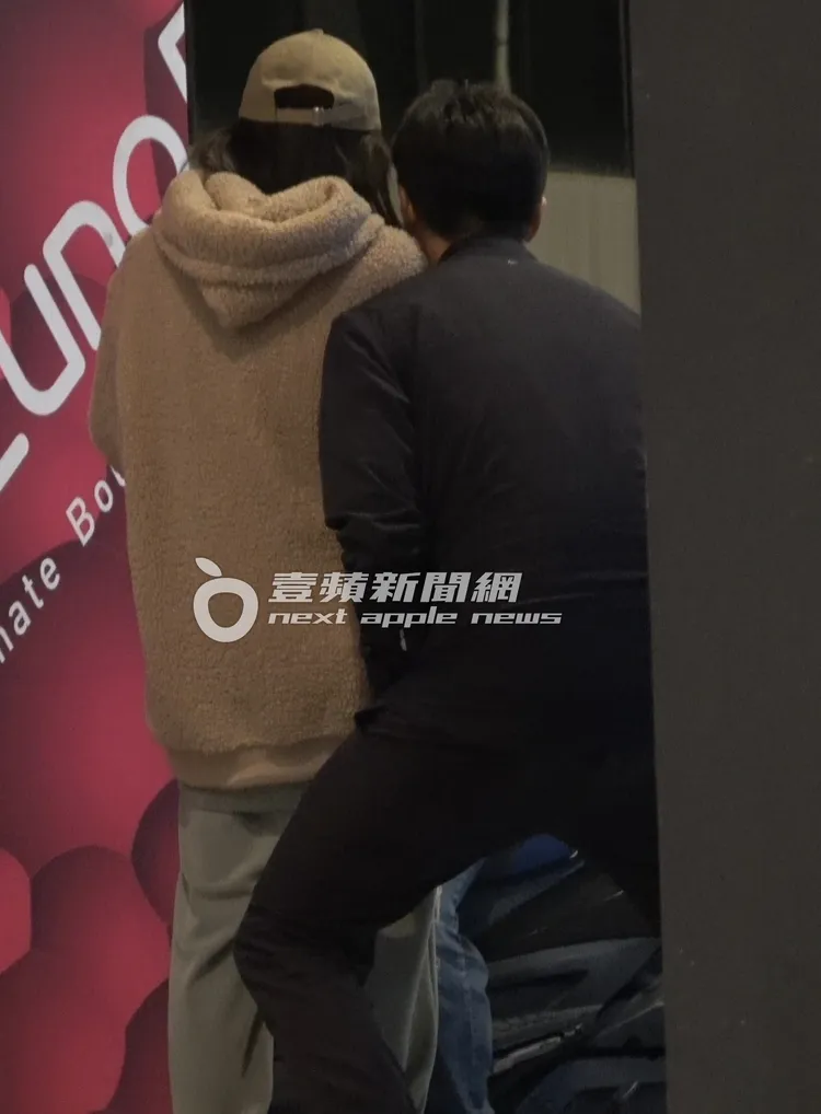  老魚（右）蹲青蛙腿配合老婆身高一起看手機畫面。特勤中心攝