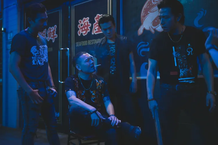 春風（左二）在《黑的教育》飾演黑道老大身邊的得力助手，演出搶鏡，右為大飛。禾豐九路提供