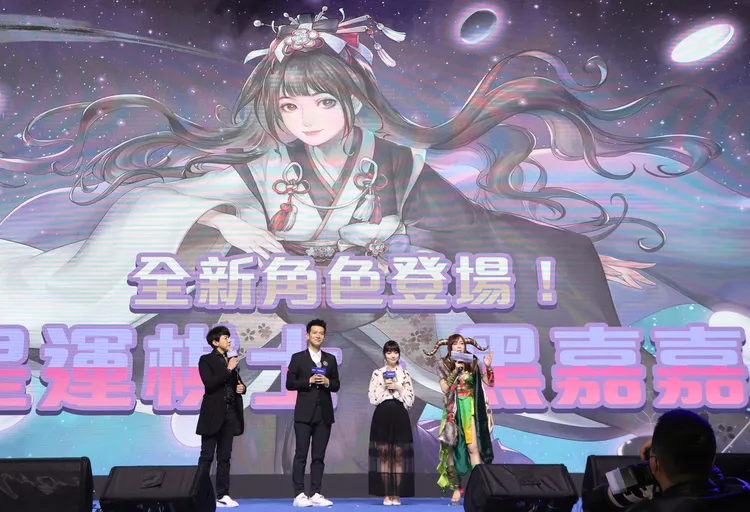 Madhead執行長Terry（左二）在電玩展最後一天公開《神魔之塔》為「全台最美女棋士」黑嘉嘉（右二）量身打造的全新角色「星運棋士 • 黑嘉嘉」。鄭孟晃攝