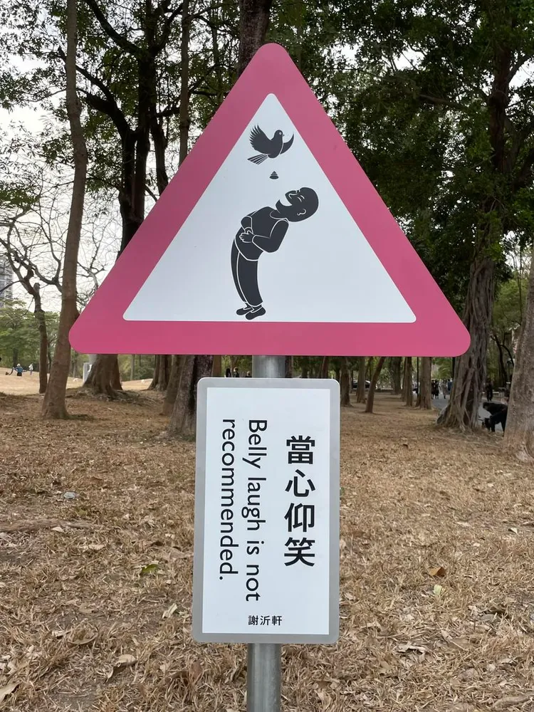 標示上飛翔的鳥兒「放屎」，恐將落入大笑的人像口中。Kai Kai Huang提供