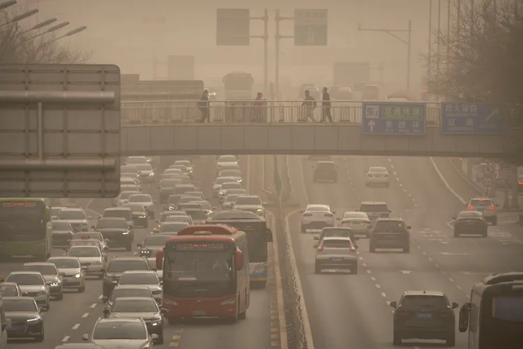 北京一座陸橋和行人22日籠罩在漫天沙塵的景象。美聯社
